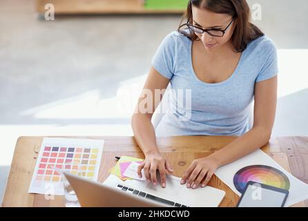 She's in her creative zone. Cropped shot of a female designer working on a project at her desk. Stock Photo