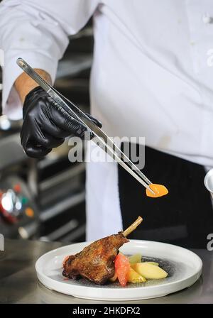 Chef Preparing Dish In Kitchen. Decorating Dish Stock Photo
