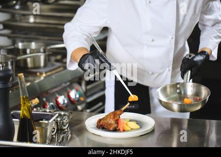 Chef Preparing Dish In Kitchen. Decorating Dish Stock Photo