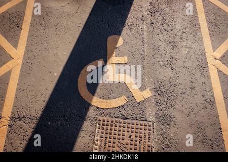 Disabled parking. Accessible parking spot. Blue badge. Yellow wheelchair sign on the ground Stock Photo