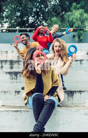 A Latina woman jokingly uses a female symbol as a magnifying glass. Stock Photo