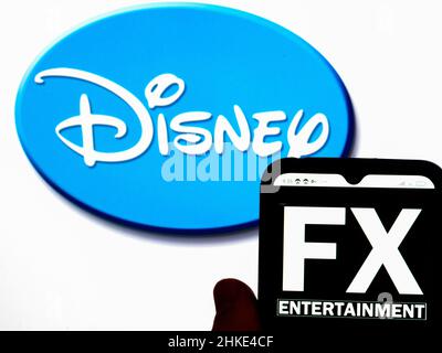 In this photo illustration, the FX Networks logo is displayed on a  smartphone screen with a Disney logo in the background Stock Photo - Alamy