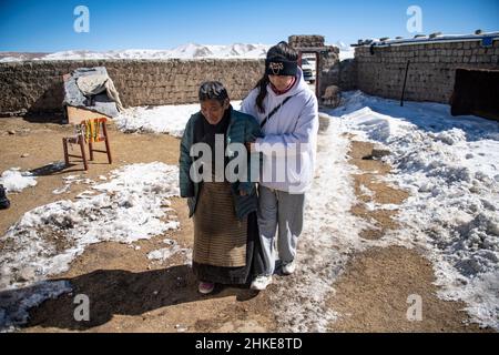 (220204) -- LHASA, Feb. 4, 2022 (Xinhua) -- Tenzin Drolma (R) assists her grandmother into their house in Gyaga Village of Damxung County, southwest China's Tibet Autonomous Region, Jan. 18, 2022. Tenzin Drolma, 21, was born on the grassland near Lake Namtso in Tibet. In 2020, she was admitted to Jiangsu Food and Pharmaceutical Science College in east China's Jiangsu Province as a Chinese pharmacy major student. The college life in the outside world is fresh to Drolma. She met many new classmates and made many friends. When winter vacation came, Drolma returned to her beloved home. 'I le Stock Photo