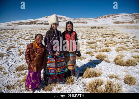 (220204) -- LHASA, Feb. 4, 2022 (Xinhua) -- Tenzin Drolma (C) stands with her mother (R) and a neighbor girl while herding cattle in Gyaga Village of Damxung County, southwest China's Tibet Autonomous Region, Jan. 18, 2022. Tenzin Drolma, 21, was born on the grassland near Lake Namtso in Tibet. In 2020, she was admitted to Jiangsu Food and Pharmaceutical Science College in east China's Jiangsu Province as a Chinese pharmacy major student. The college life in the outside world is fresh to Drolma. She met many new classmates and made many friends. When winter vacation came, Drolma returned Stock Photo