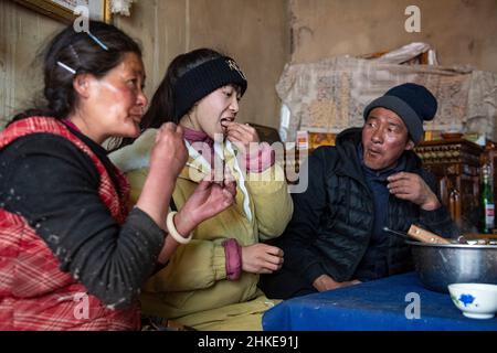 (220204) -- LHASA, Feb. 4, 2022 (Xinhua) -- Tenzin Drolma (C) enjoys lunch with her parents in Gyaga Village of Damxung County, southwest China's Tibet Autonomous Region, Jan. 18, 2022. Tenzin Drolma, 21, was born on the grassland near Lake Namtso in Tibet. In 2020, she was admitted to Jiangsu Food and Pharmaceutical Science College in east China's Jiangsu Province as a Chinese pharmacy major student. The college life in the outside world is fresh to Drolma. She met many new classmates and made many friends. When winter vacation came, Drolma returned to her beloved home. 'I leave my home Stock Photo