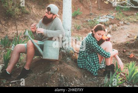 Couple Relax after hard work in spring Garden. Gardening agriculture and people concept. Gardener work. Farm. Stock Photo