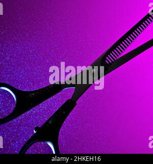 An abstract conceptual artful silhouette of thinning shears backlit against a saturated purple and pink background with a glowing misted spray Stock Photo