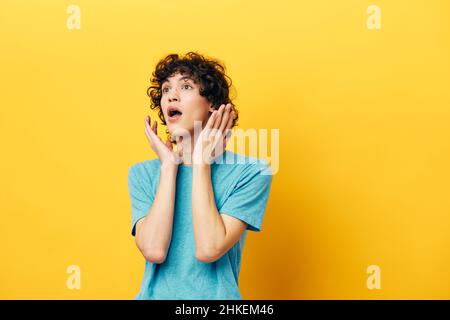 guy on a yellow background in a blue t-shirt emotions Stock Photo