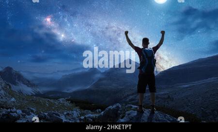 Hiker in the mountains under a starry night sky Stock Photo