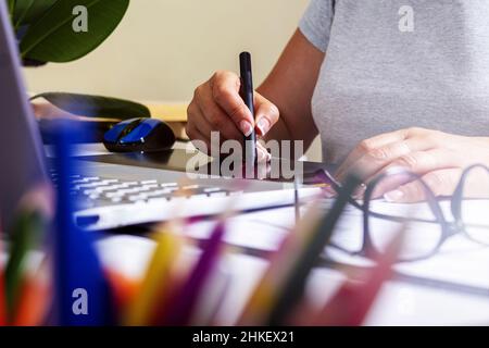 Woman working on graphics tablet with stylus.  Stock Photo