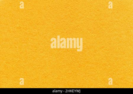 Texture of bright yellow and orange colors paper background, macro. Structure of dense golden kraft cardboard. Felt backdrop closeup. Stock Photo