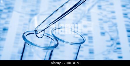 Pipette and test tube with DNA in the background Stock Photo