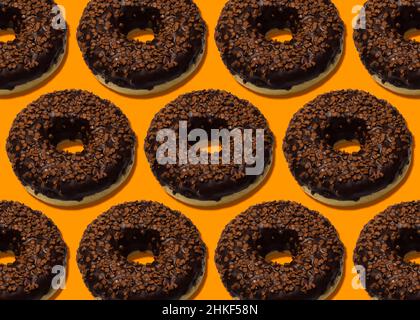 delicious donuts with dark chocolate isolated on orange background 4 Stock Photo