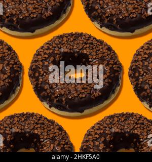 delicious donuts with dark chocolate isolated on orange background Stock Photo