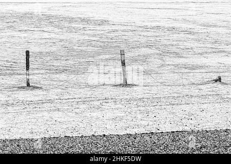 A telephoto shot of three fence posts; one that is broken, Mexican Highway 3, Baja California, Mexico. Stock Photo