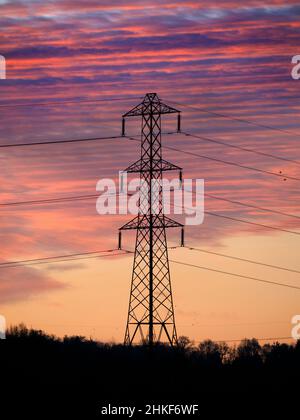 Electricity pylon silhouetted against a vivid blue sky Stock Photo - Alamy