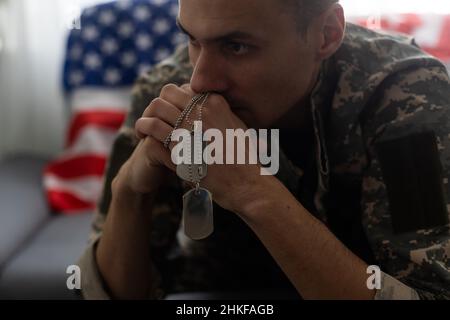 man in military uniform crying USA flag background. Stock Photo