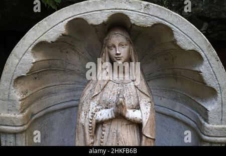 Loozen, Netherlands - Aug 18 2021 A garden statue of mother Mary with rosary in Ada Hofmans Pond Gardens Stock Photo