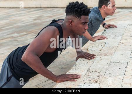 Friends doing pushups in park Stock Photo