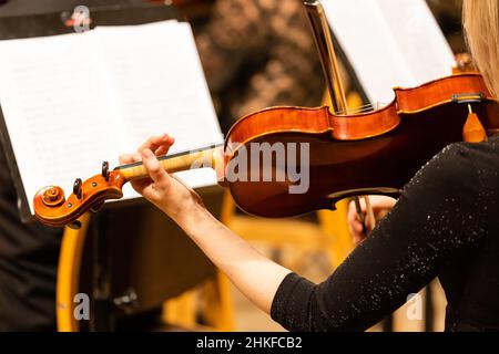Symphony orchestra on stage, hands playing violin Stock Photo