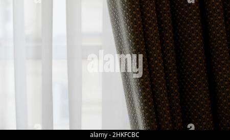 Voile curtain in front of window with textured pleated fabric to side Stock Photo