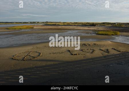 Peace sign, stay safe, and love made out of rocks on a beach. Stock Photo