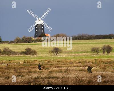 Wildfowling at a Norfolk Marsh. Burnham Overy Staithe Windmill in background Stock Photo