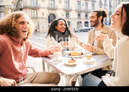 Friends group toasting latte at coffee bar terrace. Group of people talking and having fun together at cappuccino restaurant. Lifestyle concept with Stock Photo