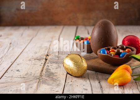 Colorful chocolate Easter eggs on wooden table Stock Photo