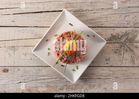 Beef steak tartare on wooden table Stock Photo