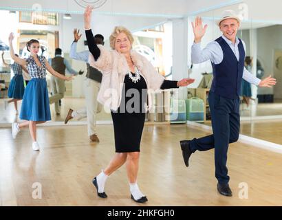 Mature woman dancing swing with young man Stock Photo