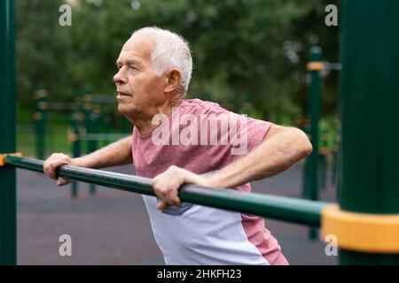 Senior european man doing push-ups outdoors Stock Photo