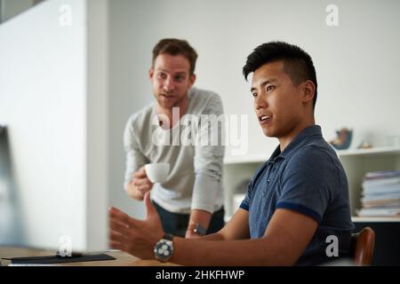 Putting their heads together. Cropped shot of two designers working together on a project in an office. Stock Photo