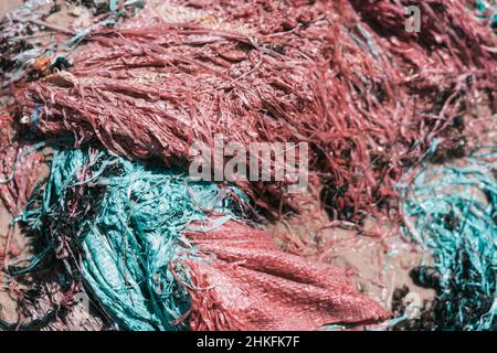 Real nature abstract beauty background. Copy space soft bag cloth rag fabric flap texture surface material on sand ground. Blue red colour. Design Stock Photo