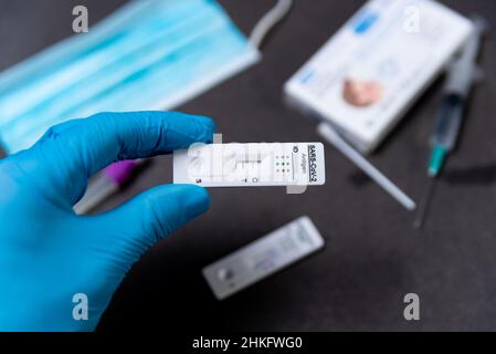 Spain. 04th Feb, 2022. A hand wearing a protective glove is seen holding a rapid Covid test, also known as antigen test or lateral flow test, showing a positive result in a close up on a table in Barcelona, Spain on February 04, 2022. Covid self tests demand has increased exponentially due to the spread of the covid-19 Omicron variant. (Photo by Davide Bonaldo/Sipa USA) Credit: Sipa USA/Alamy Live News Stock Photo