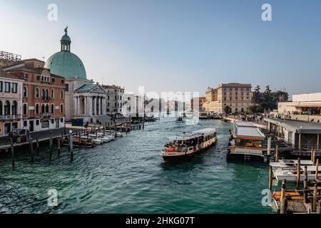 Venice,Italy-January 28,2022.View of Grand Canal with vaporetto,Venetian public waterbus carrying passengers,small boats and gondola.Water transport Stock Photo
