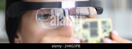 Master repairman in goggles looking at computer microchip Stock Photo