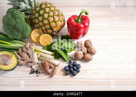 Vegetarian food with anti-inflammatory and antioxidant effect, arrangement of vegetables, nuts, fruits and spices on a light wooden background with co Stock Photo