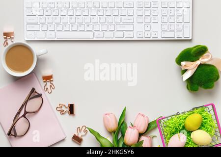Desktop. Glasses coffee cups keyboard notepad on a table with easter decorations. Top view flat lay copy space Stock Photo