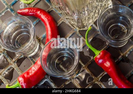 glass of vodka with hot peppers on dark background Stock Photo