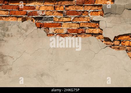 Old brick wall with fallen off plaster. Background of crack brick wall texture Stock Photo