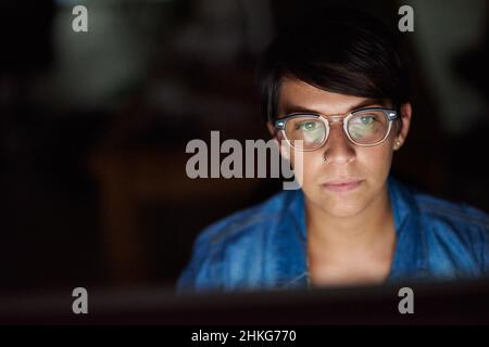 Putting in some overtime. Cropped shot of a young woman working late in her office. Stock Photo