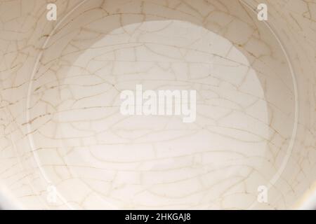 cracked glaze on the bottom of a white ceramic cup Stock Photo