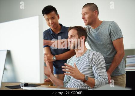 I need some input on this.... Cropped shot of three designers working together on a project in an office. Stock Photo