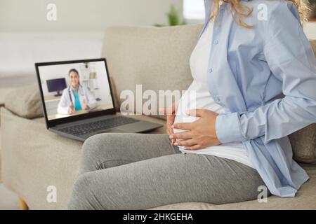 Young pregnant woman having telemedicine consultation with online doctor on laptop Stock Photo