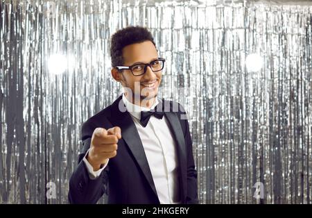 Happy black man in glasses and stylish suit pointing finger at camera and smiling Stock Photo