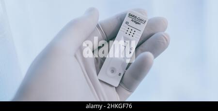 Closeup view of gloved hand with SARS-CoV-2 rapid antigen test nasal. Self test verifies positivity covid-19. Health, healthcare protection, contagion Stock Photo