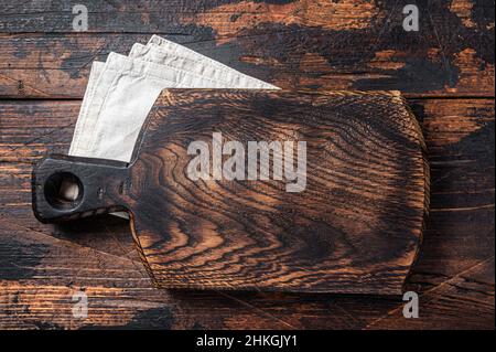 Empty wooden Cutting board over towel on kitchen table, healthy cooking background. Wooden background. Top view. Copy space Stock Photo