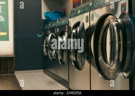 Laundromat inside in the evening, washing machines in a laundromat Stock Photo