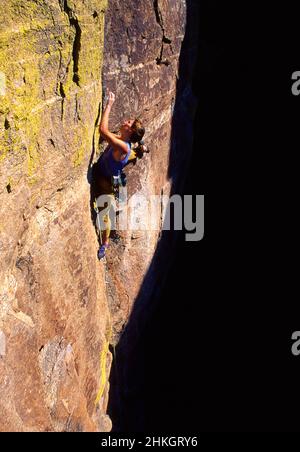 Female rock climber climbing a difficult route at Windy Point. Santa Catalina Mountains, Arizona Stock Photo